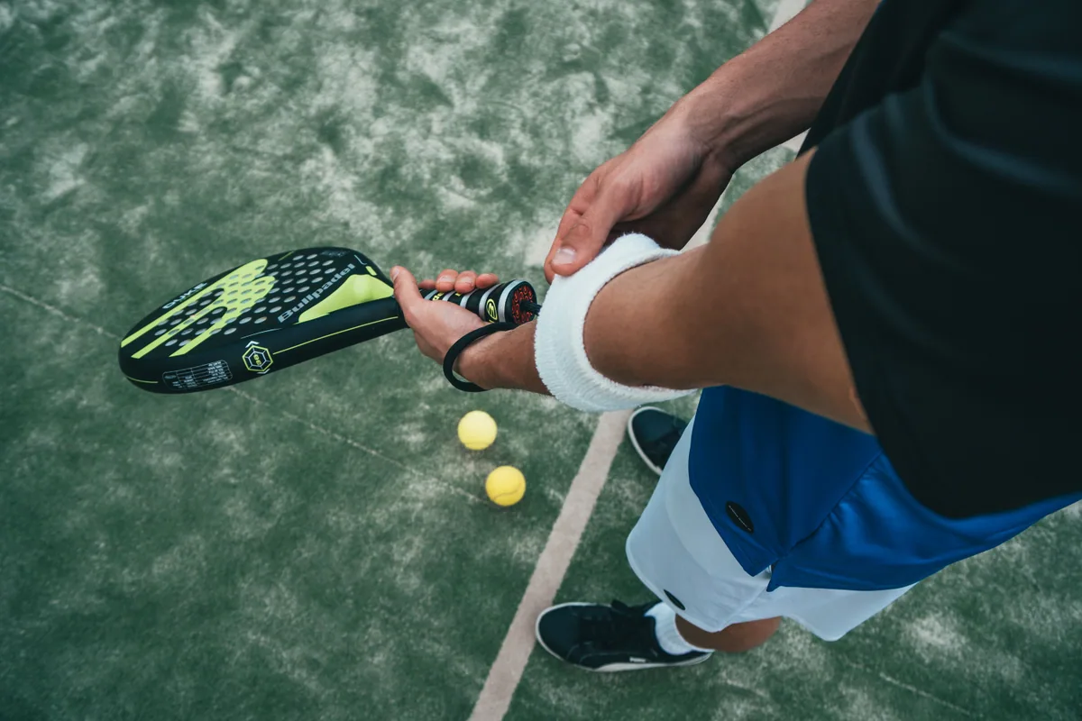 Player holding a padel racket on court