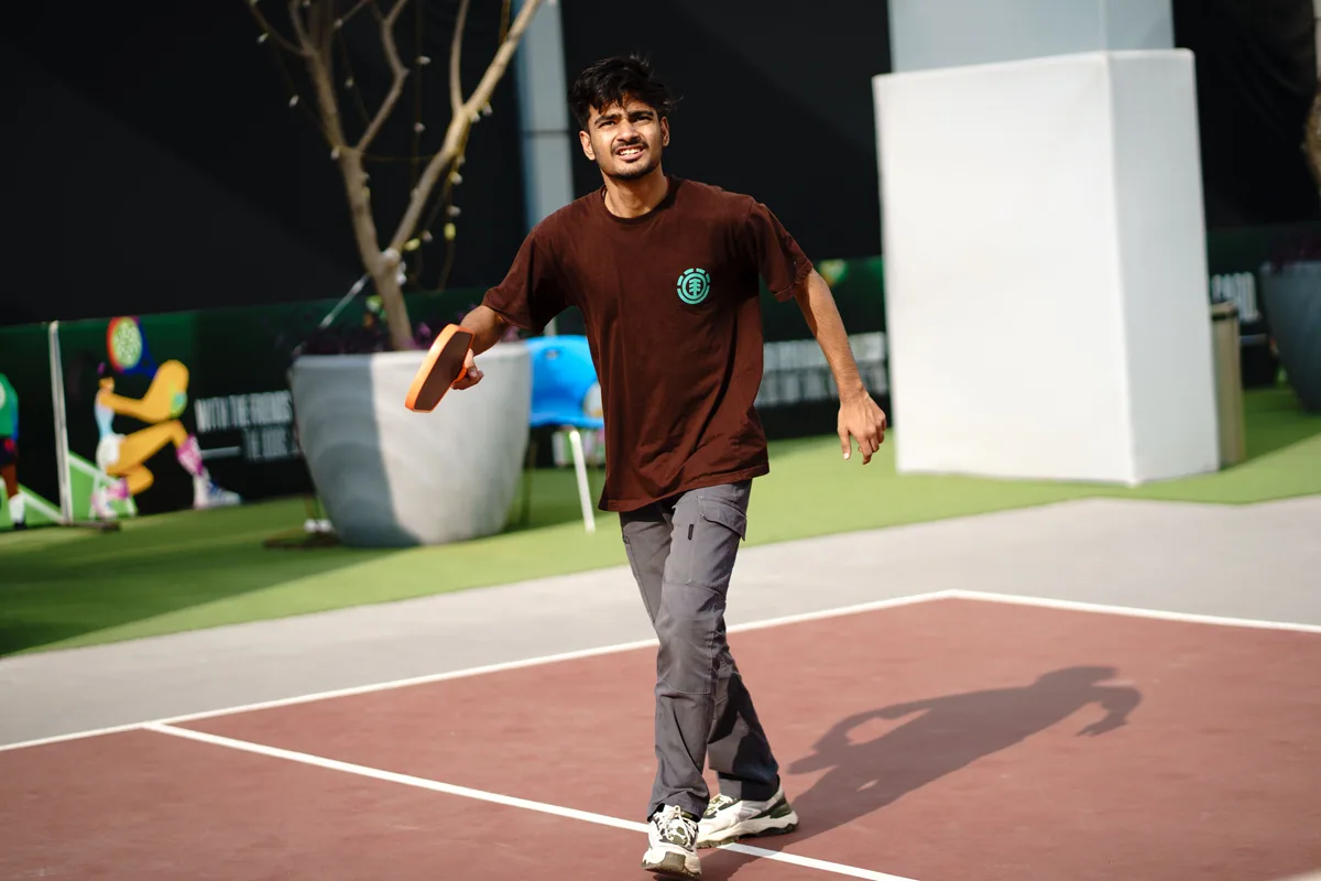 Player holding a pickleball paddle on an outdoor court