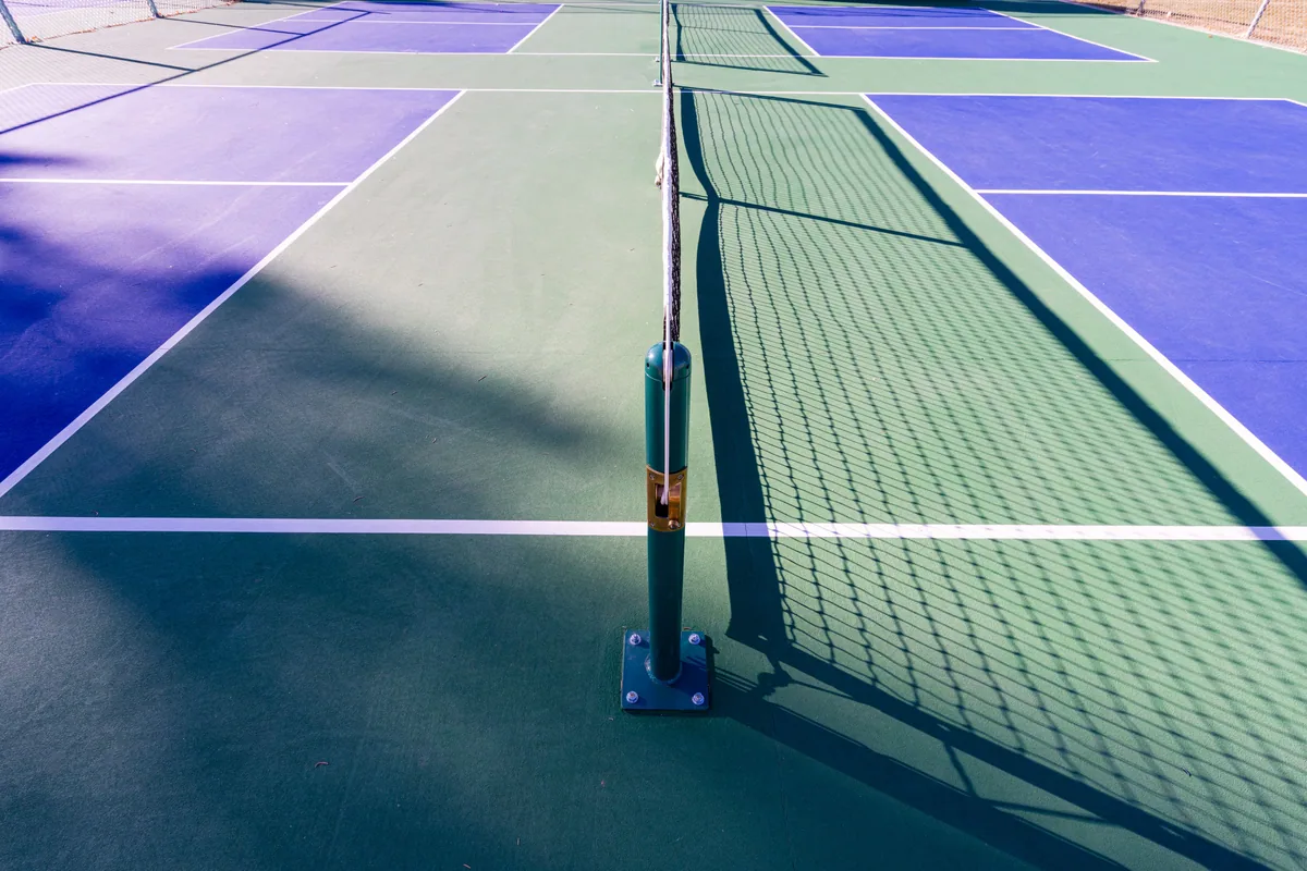 Outdoor pickleball court showing the net and non-volley-zone lines