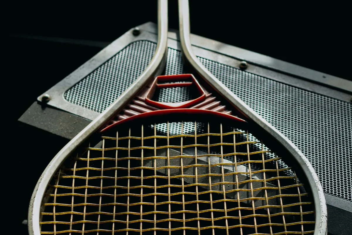 Close-up of a tennis racket stringbed on a metal bench